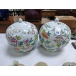 A pair of Chinese famille rose ginger jars and covers; decorated with flowers