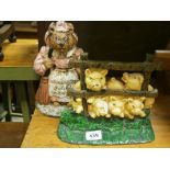 Two painted cast iron door stops; one in the form of pigs behind a gate and the other in the form of