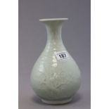 A Chinese porcelain light green celadon vase, of bulbous form, with raised blossom decoration,