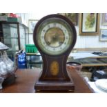 A Edwardian mahogany balloon inlaid mantle clock; raised on four brass feet