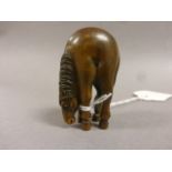 A fruitwood netsuke in the form of a horse