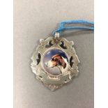 A silver watch fob with enamel plaque depicting a dog