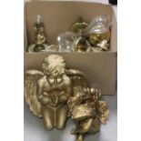 A box of brass oil lamp fittings; together with a pair of gold painted cherub figures and brass