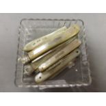 A group of five mother of pearl handled folding fruit knives; each with hallmarked silver blades