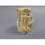 Signed oxbone netsuke of a man with fan and basket