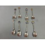 A small collection of hallmarked silver and enamel collectors spoons (8)