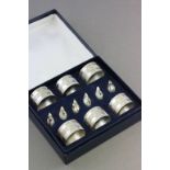 A set of six silver plated napkin rings; together with a set of place holders in the form of ducks