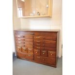 A vintage oak stationary chest of sixteen drawers with central locking