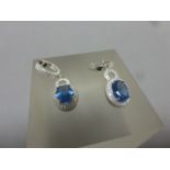 A pair of silver, CZ & blue topaz drop earrings