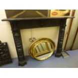 A Victorian style cast iron fire surround; cast with putti, bird and scroll decoration; the internal