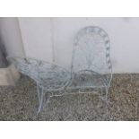 A painted metal garden loving seat