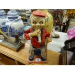 Vintage Japanese TN tin plate toy of man smoking a cigarette on a suitcase