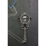 Silver and garnet magnifying glass on silver chain