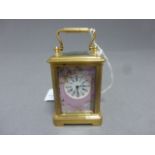 A brass cased miniature carriage clock with porcelain panels, working order