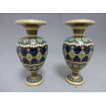 A pair of Victorian/Edwardian ceramic vases, each with raised coloured decoration