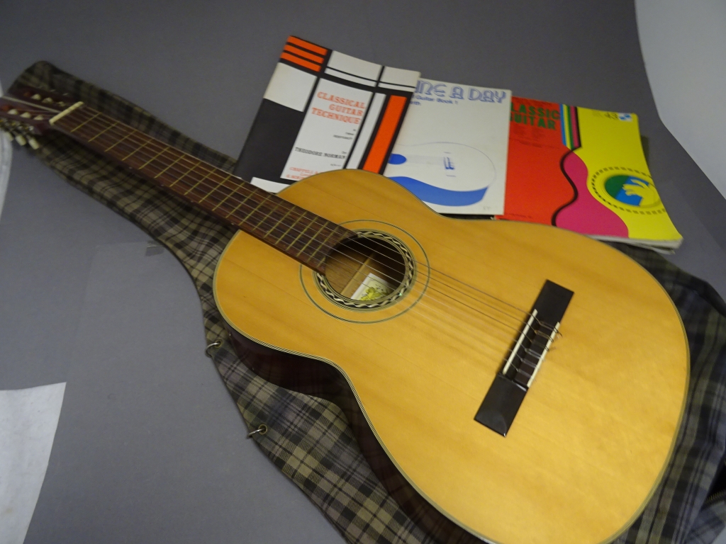 A Suzuki guitar, no 1663, made in Japan, along with various "How to learn" guides