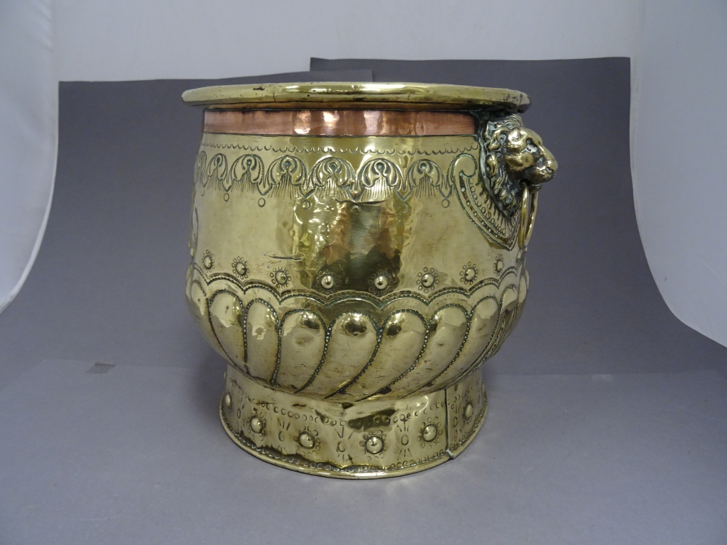 A Victorian two handled copper coal bucket, with lion head handles, hammered and studded