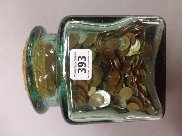 Glass jar of mixed world coinage