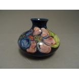 An early 20th century Moorcroft squat vase, in the clematis patten, with applied Queen Mary Label,