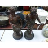 Pair of spelter early 20C figures of a male and female on mahogany pedestal