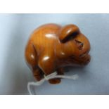 A carved Japanese wooden figure of a pig signed to the underside