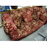 A button back sofa, upholstered in a red velvet fabric, on mahogany turned legs