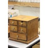 A vintage rustic pine table top bank of five drawers