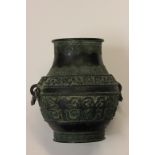 A Chinese two handled bulbous bronze, with swing rope twist loops, repeated patterns throughout, H