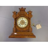 An oak cased mantel clock, with an American Ansonia movement