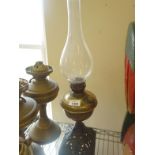 Victorian period brass oil lamp on decorative metalware base with glass top