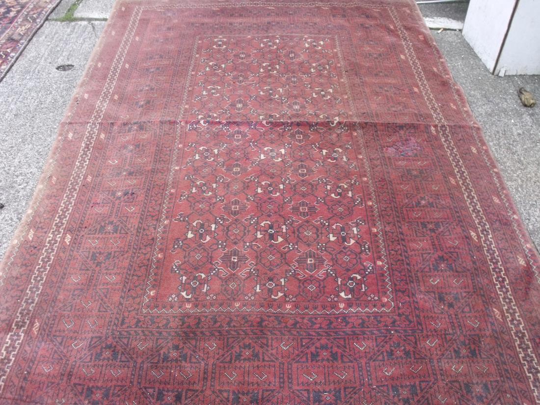 An antique red ground rug 8'6” x 5'4”