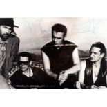 U2 photograph signed by all four band members. A black and white publicity photograph for Joshua