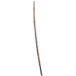 An Oceanic tribal long bow. Of circular profile, the upper third of the stave bound with twine.