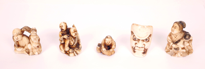 A collection of four Japanese carved ivory netsuke and a miniature mask. The netsuke in the form