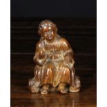 A Small 16th/17th Century Southern Netherlandish Walnut Carving of a seated child wearing a long