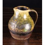 An Earthenware Jug; the ribbed body with mottled green glaze, 6½ ins (16.5 cms) in height.