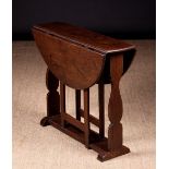 A Small Early 18th Century Oak Gateleg Table with circular top on shaped baluster end board