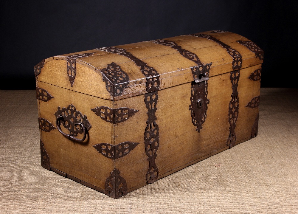 A Large 17th Century Dome Topped Oak Coffer bound in decoratively pierced iron straps,