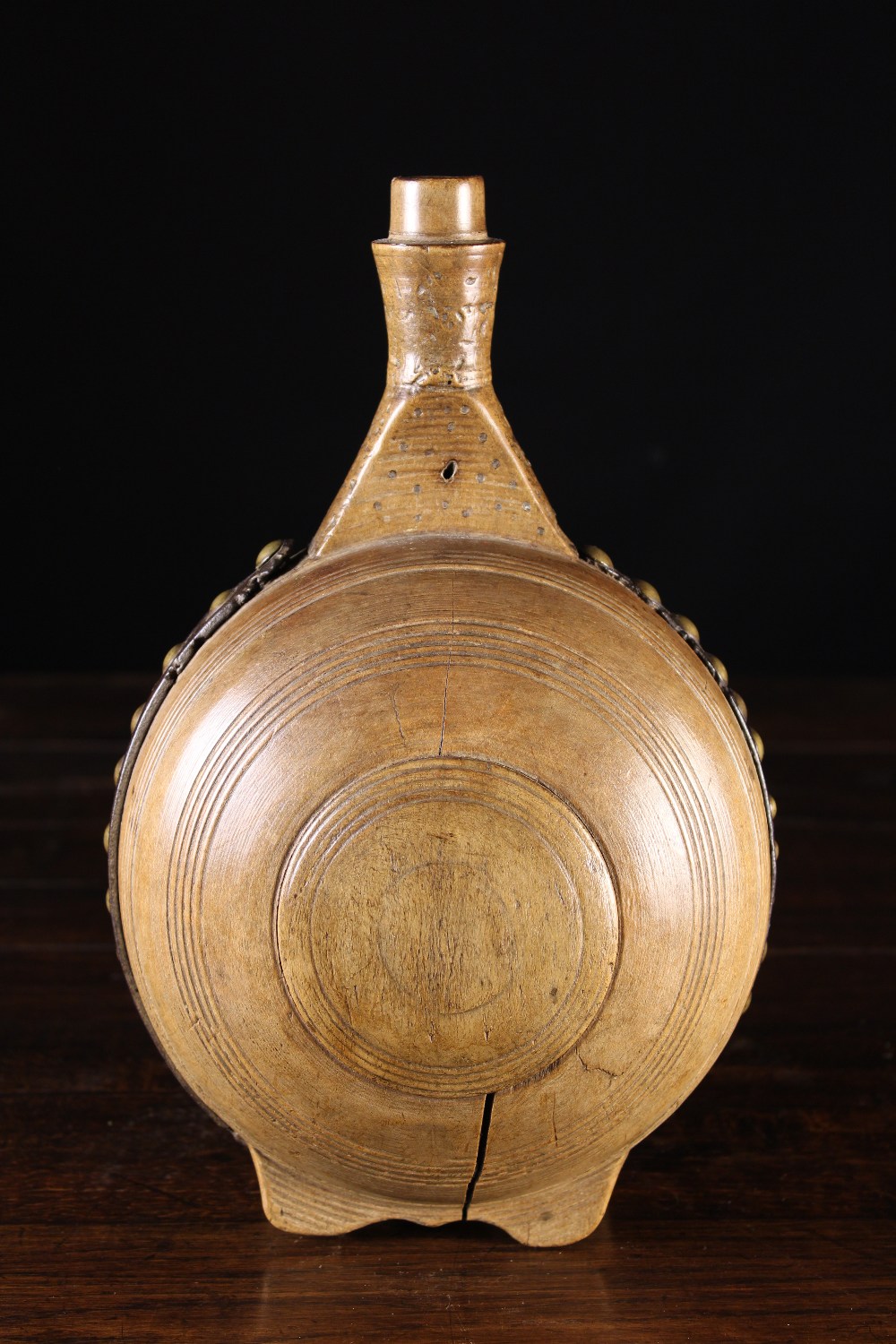 An 18th Century Pole Lathe Turned Sycamore Pilgrim's Flask bound in a brass studded leather strap,