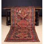 An Old Carpet Runner woven with six medallions in a banded border in beige, dark rose, blue,