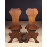 A Pair of George III Mahogany Planked Oak Hall Chairs of sgabello inspired design.