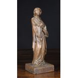A 17th Century Carving of a Female Saint holding a book, mounted on a square burr figured base,