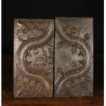 Two Similar Early 16th Century Carved Oak Panels enriched with a scrolling band bordered by