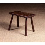 A 19th Century Rustic Elm Stool with remnants of original claret red paintwork.