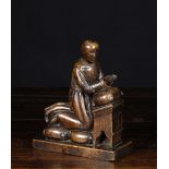 A Carved Oak Pew-end Finial in the form of a praying monk, 8¼ ins (21 cms) in height, 6½ ins (16.