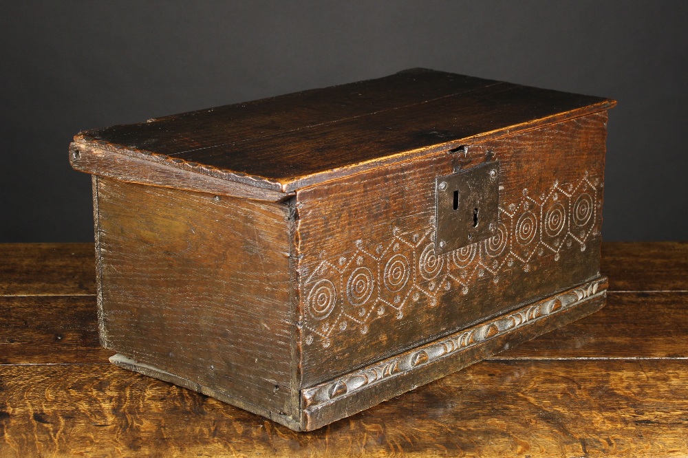 An 18th Century Boarded Oak Box. The lid with engrailed ends on wooden pivots.