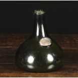 An 18th Century Green Glass Bottle with kick up base and an oval seal to the side,