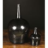 Two 18th Century Dark Glass Bottles: One large with a tall tapering neck and bulbous body 18 ins