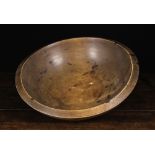A Large 19th Century Dairy Bowl of turned beech-wood, 7 ins (18 cms) high,