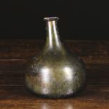 A 17th Century Iridescent Green Glass Onion Bottle with kick up base, 6½ ins (16.5 cms) in height.